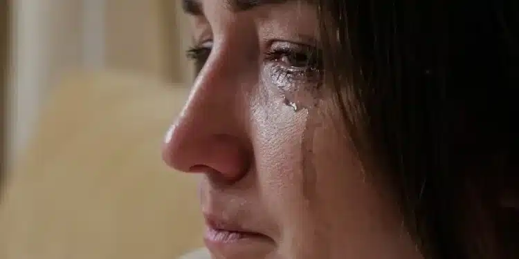 Mulher com lágrimas escorrendo pelo rosto, refletindo emoções intensas e choro repentino
