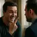 Homem sorrindo de forma irônica apontando o dedo para outro homem durante conversa