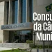 Fachada da Câmara Municipal com bandeira do Brasil e informações sobre concursos públicos.
