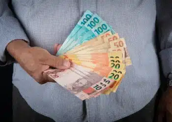 Notas de dinheiro com valores de R$ 10, R$20, R$50 e R$100, representando o 13º salário do INSS para aposentados e pensionistas que recebem acima de um salário mínimo.