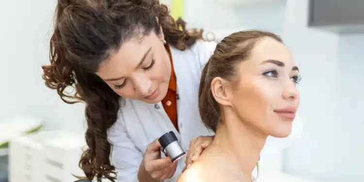 Dermatologista examinando a pele de uma paciente com dermatoscópio durante avaliação clínica.