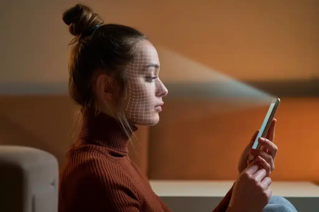 Mulher utilizando smartphone com reconhecimento facial para validação de identidade, com a captura digital em processo