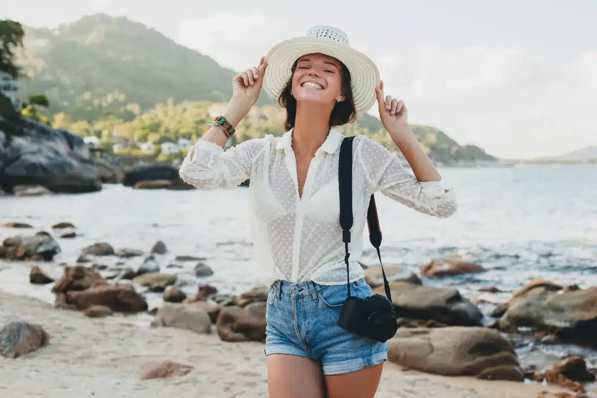 Turista sorrindo em praia aproveitando folga prolongada durante feriado de abril