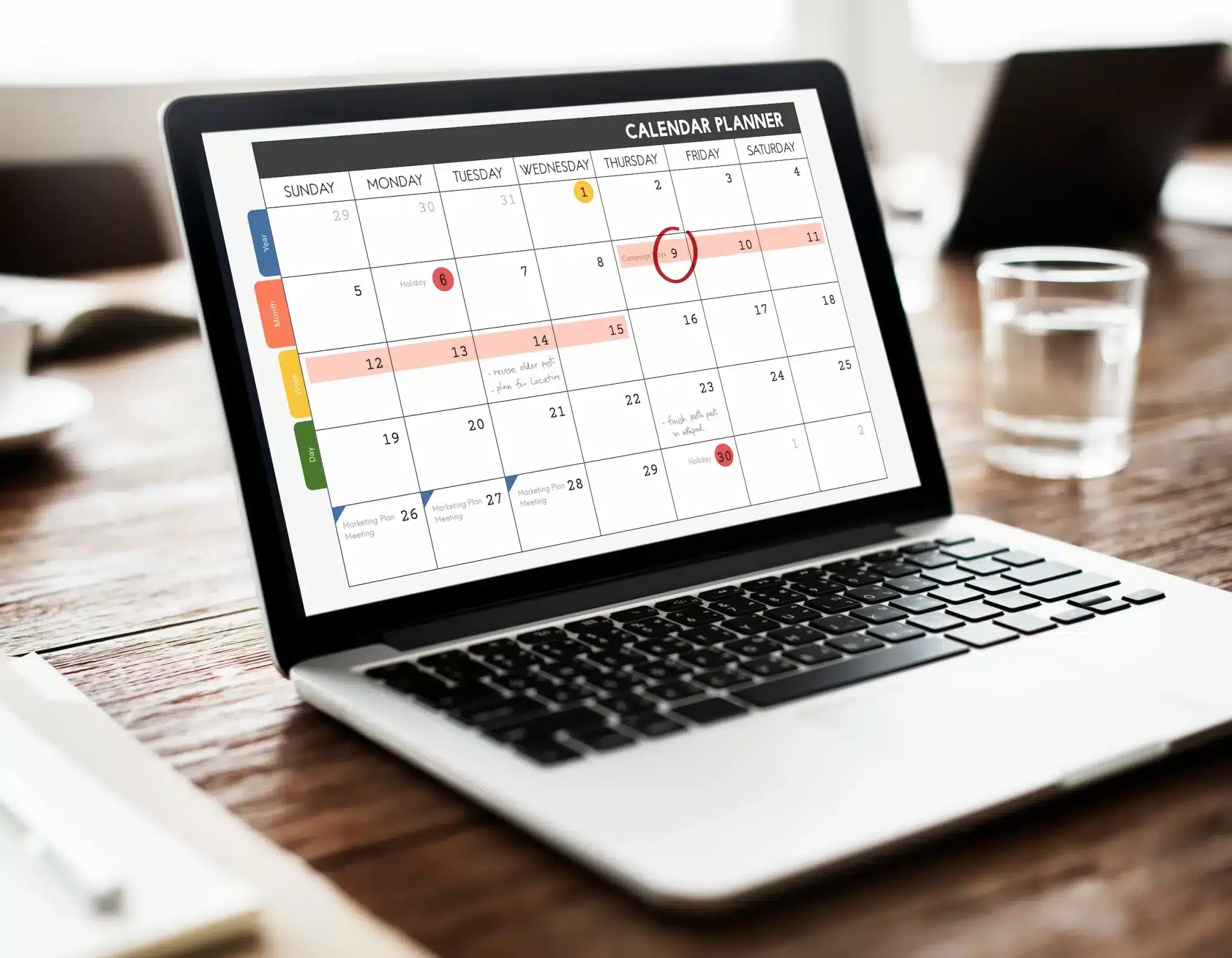 Notebook aberto sobre mesa de madeira exibindo calendário com dias destacados, representando a emenda do feriado de Tiradentes em 21 de abril de 2026