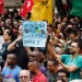 Manifestação com trabalhadores segurando cartaz pedindo fim da escala 6x1 e redução da jornada de trabalho no Brasil.