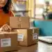 Mulher organizando pacotes de compras em uma mesa, representando a proposta do governo sobre a eliminação da taxa das blusinhas.