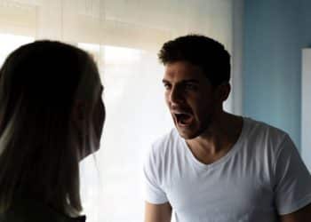 Homem gritando para mulher durante discussão em ambiente doméstico, refletindo um comportamento tóxico.