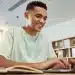 Jovem utilizando notebook representando as inscrições online para os cursos gratuitos de capacitação profissional.
