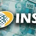 Logo do INSS sobre notas de 100 reais, relacionado ao pagamento do benefício de R$ 2.431,50 em 2026.