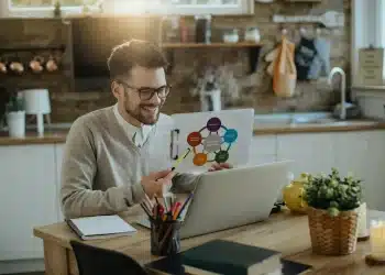 Profissional trabalhando remotamente em casa, analisando dados e se adaptando às novas exigências do mercado de trabalho.