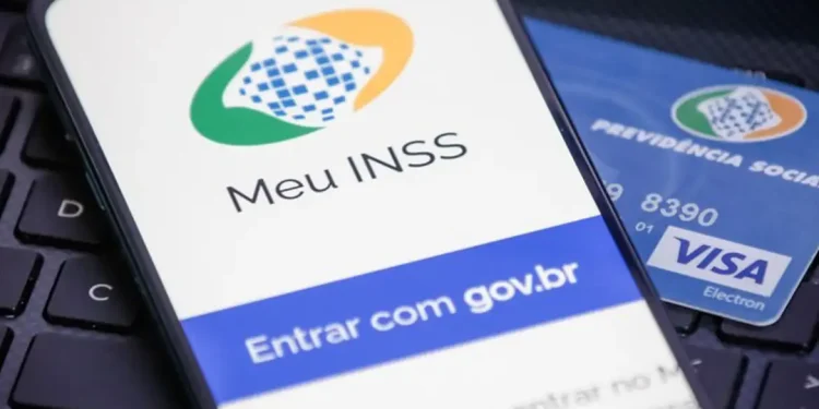 Celular exibindo a tela de login do aplicativo Meu INSS ao lado de cartão da Previdência Social, representando a consulta ao 13º salário com as mudanças de valores e isenção de IR em 2026