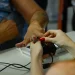 Atendente realiza coleta de biometria das digitais de cidadão em posto de atendimento, ilustrando o cadastro biométrico exigido para programas sociais até dezembro de 2026