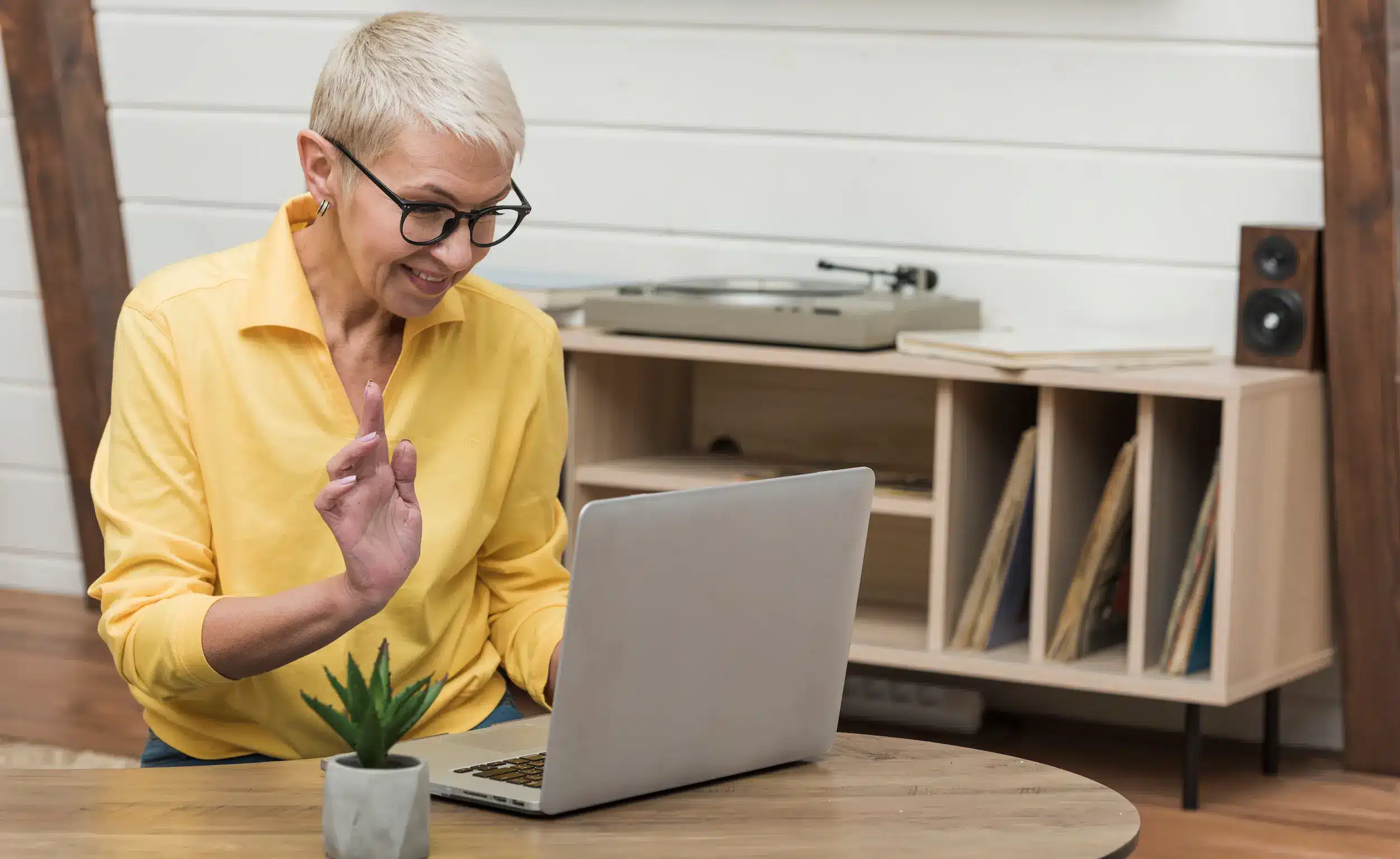 Mulher madura usando notebook em casa, simbolizando trabalho online flexível após os 50 anos.