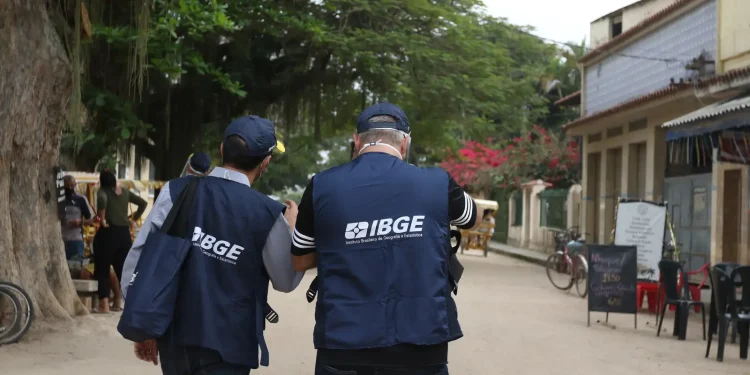 Recenseadores do IBGE com colete azul em campo representando o concurso para recenseador 2026