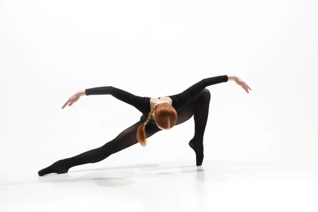 Bailarina em movimento contemporâneo com postura técnica e equilíbrio, representando as múltiplas funções do profissional da dança regulamentado