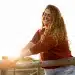 Mulher sorrindo ao ar livre durante um momento tranquilo de solitude e bem-estar emocional.