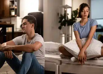 Casal em silêncio após desentendimento, refletindo sobre a frase 'Preciso de um tempo' em um ambiente íntimo.