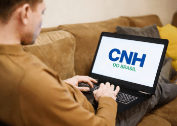 Homem olhando para a tela do notebook com o nome "CNH no Brasil".