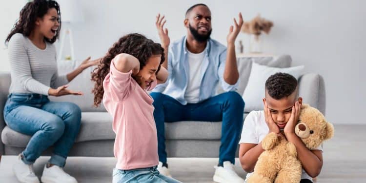 Crianças sofrem com conflito familiar enquanto pais discutem.