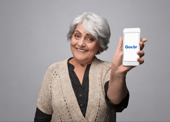 Idosa exibindo tela do celular com nome "Gov.br".
