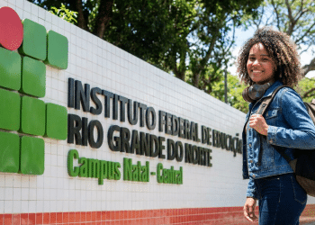 Estudante sorridente na entrada do IFRN Campus Natal-Central.