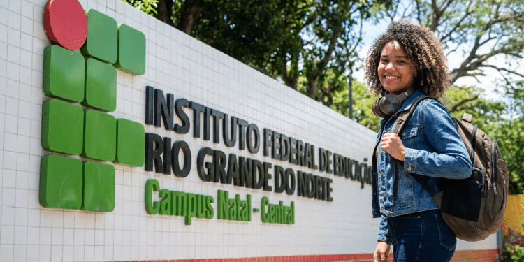 Estudante sorridente na entrada do IFRN Campus Natal-Central.