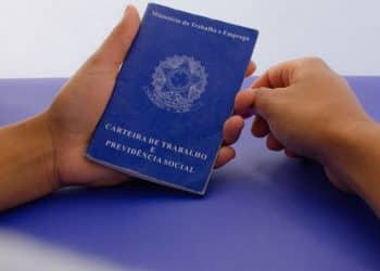 Carteira de Trabalho física do Brasil em mãos de trabalhador.