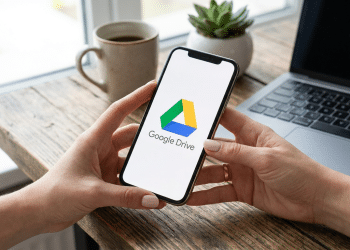 Google Drive em smartphone com laptop e café em ambiente doméstico.