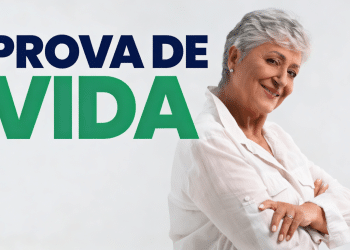 Mulher idosa de cabelos grisalhos curtos sorri, vestindo camisa branca, ao lado do texto "Prova de Vida".