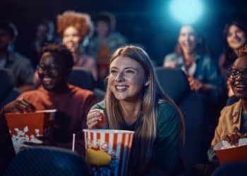 Jovens assistindo filme no cinema.