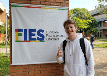 Estudante comemora aprovação no FIES em campus universitário.