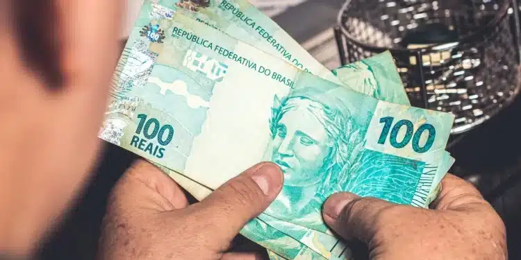 Pessoa segurando notas de 100 reais simbolizando possível aumento do BPC/INSS.