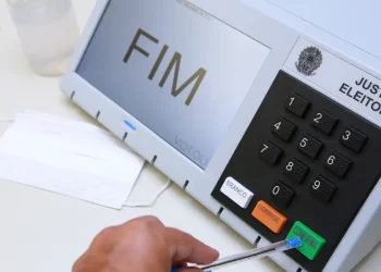 Urna eletrônica da Justiça Eleitoral com a tela exibindo a palavra FIM, representação do encerramento do prazo de regularização do título de eleitor para as eleições de 2026.