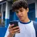 Estudante consultando no celular informações sobre os pagamentos do Pé-de-Meia liberados em maio