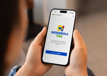 Mãos segurando smartphone exibindo tela do aplicativo Desenrola FIES com botão Entrar com gov.br.
