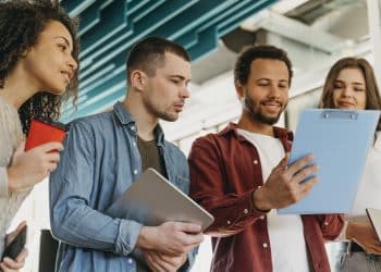 Grupo de jovens profissionais analisando documentos em ambiente de trabalho moderno e colaborativo