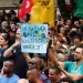 Manifestantes em ato público erguendo cartaz com a frase fim da escala 6x1 reduza a carga horária já.