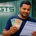 Trabalhador segurando dinheiro e consultando documento, com o logo do FGTS ao lado, representando as regras do saque-aniversário e os sete lotes de pagamento previstos para 2026.