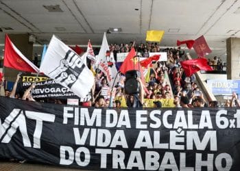 Manifestantes erguem uma faixa pelo fim da escala 6x1