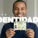 Homem sorrindo segura a nova Carteira de Identidade Nacional com o destaque Nova Identidade ao lado