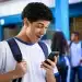 Estudante do ensino médio consultando no celular o benefício do Pé-de-Meia, representando a gratuidade no Enem 2026 e o incentivo extra de R$ 200.