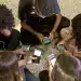 Grupo de adolescentes sentados em roda mexe em celulares, cena que ilustra o público afetado pela nova classificação indicativa do YouTube