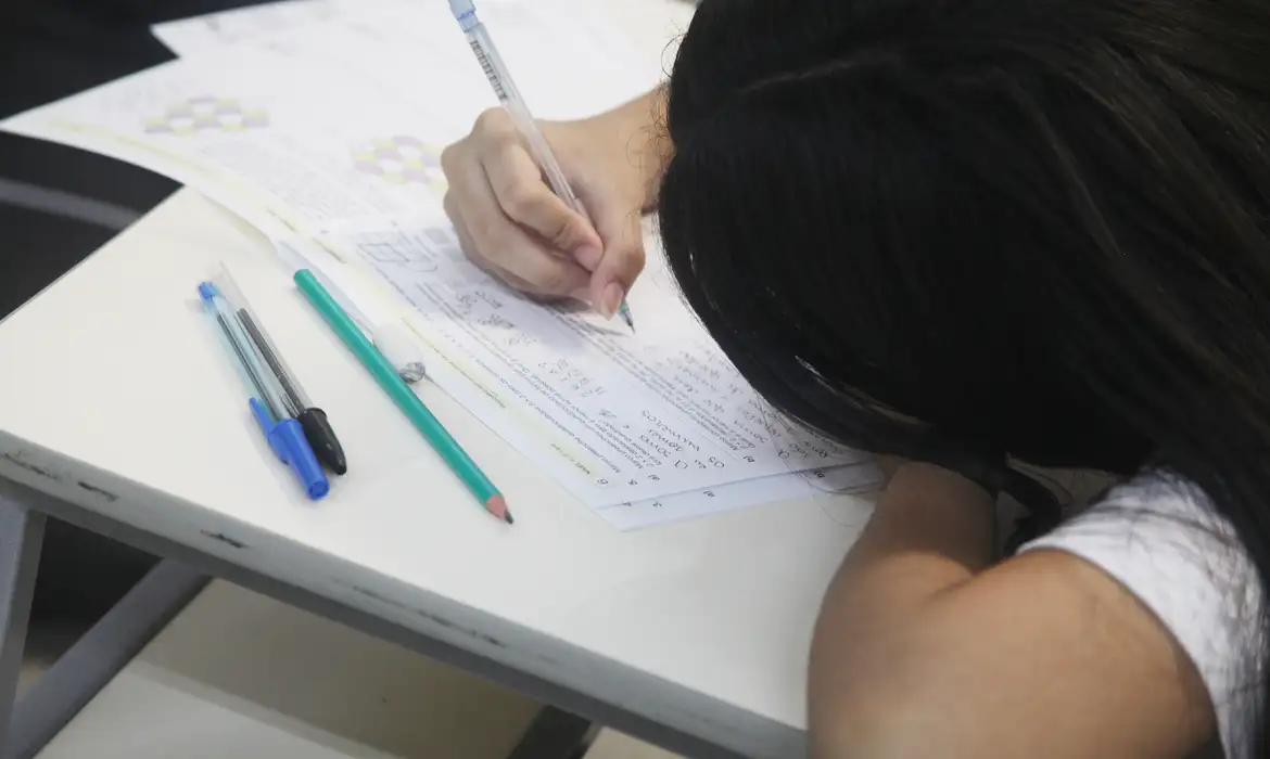 Estudante escreve durante a aplicação de prova, em referência à queda no número de notas 1.000 na redação do Enem.