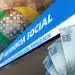 Fachada da Previdência Social com cédulas de reais sobrepostas, ilustrando os novos pagamentos do INSS para brasileiros selecionados