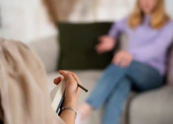 Jovem conversa com terapeuta durante sessão de atendimento psicológico