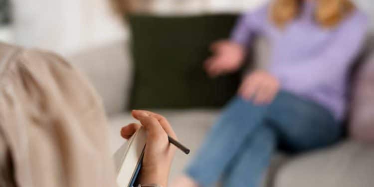 Jovem conversa com terapeuta durante sessão de atendimento psicológico