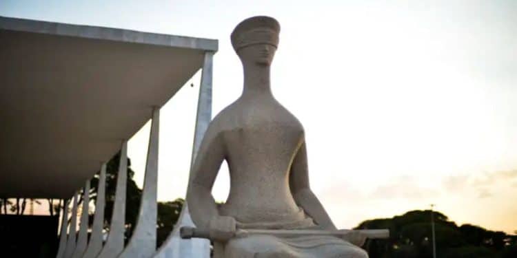 Escultura A Justiça em granito com olhos vendados e espada sobre o colo
