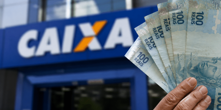 Mão segurando cédulas de cem reais em frente a uma agência da Caixa, em referência ao Saque Calamidade do FGTS de até R$ 6.220 liberado para novos municípios em 2026.