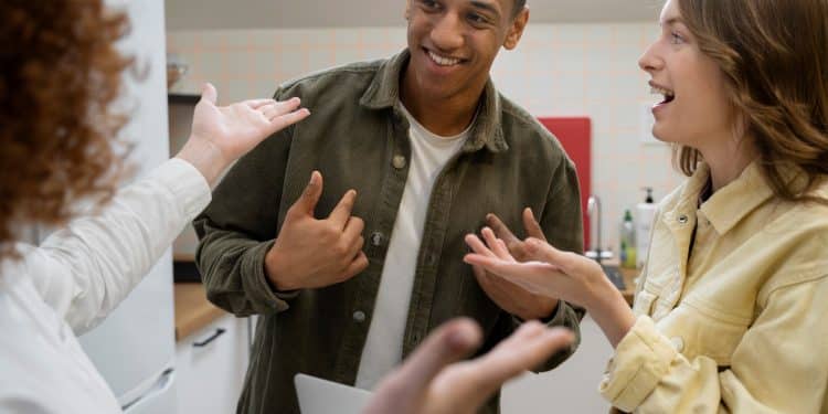 Três jovens conversando animadamente em ambiente descontraído com gestos expressivos