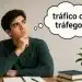 Pessoa pensativa olhando para um balão com a pergunta “tráfico ou tráfego?”, representando uma dúvida comum de português.